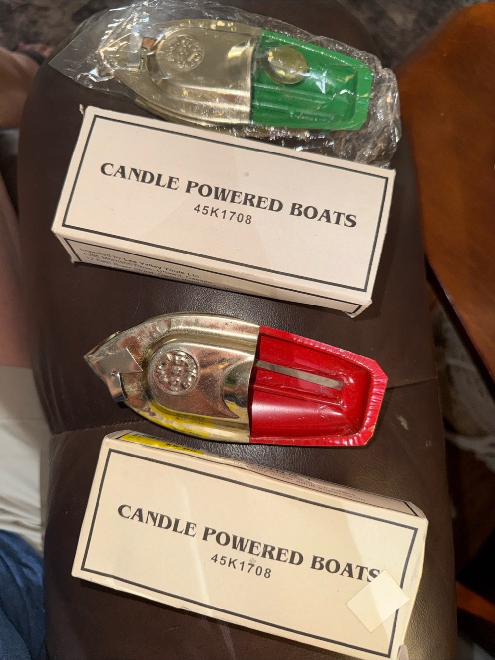 Two vintage candle-powered "pop-pop" or "putt-putt" tin steam boats.